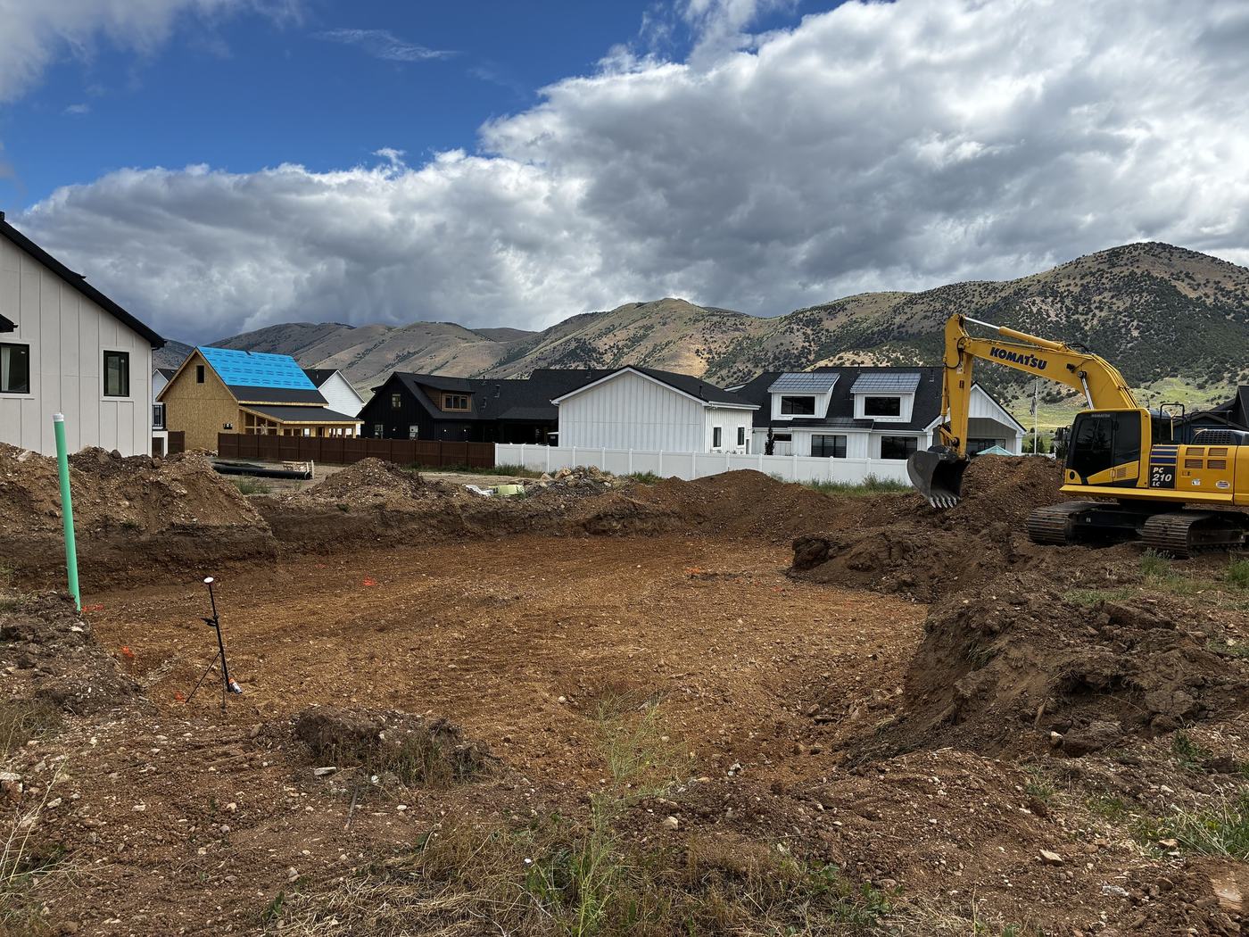 An excavator beside a freshly dug basement hole on an Ogden area job