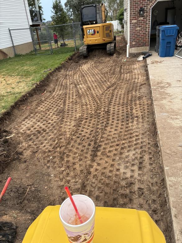 A graded and compacted strip along a residential driveway