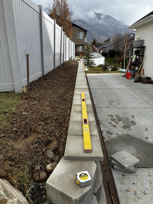A level laid across the cap blocks of a finished wall