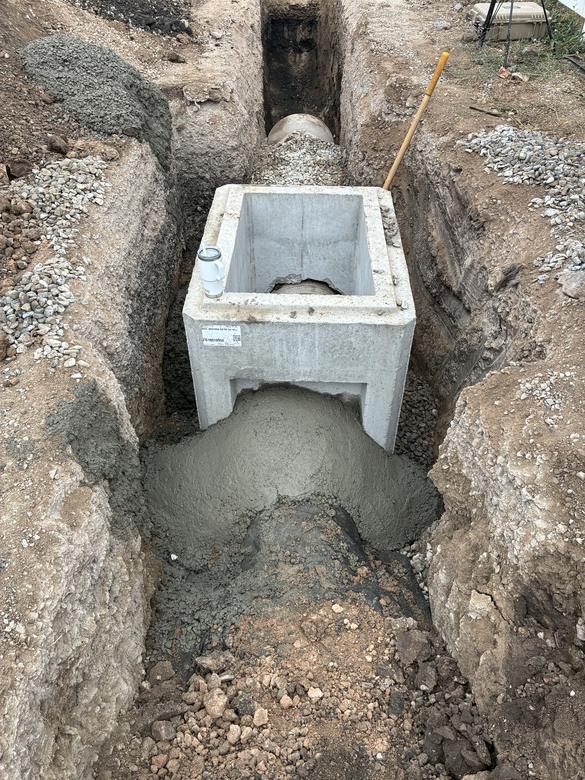 A precast box structure set over the pipe and grouted in