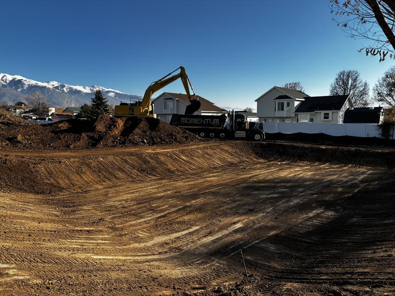 A wide pad dug out beside finished homes, loading trucks off the bank