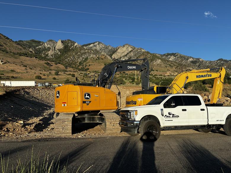 Two excavators and the company truck working a site together