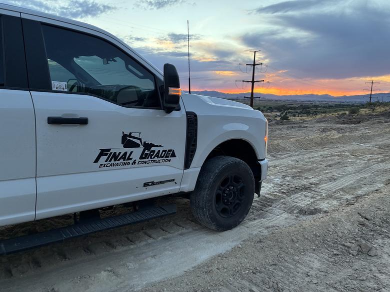 The Final Grade truck on a freshly graded site at sunset