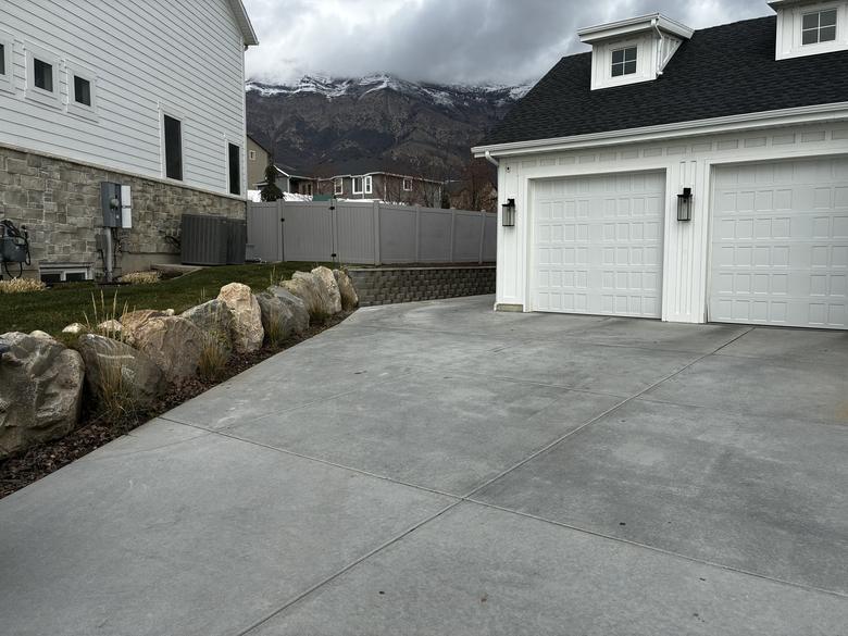 Boulder edging set along a lawn with a low block wall behind it