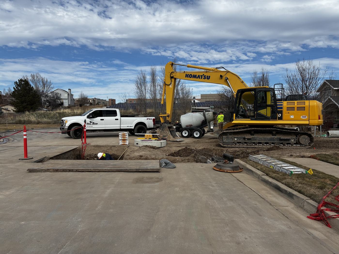 The Final Grade crew working an open utility trench in a street